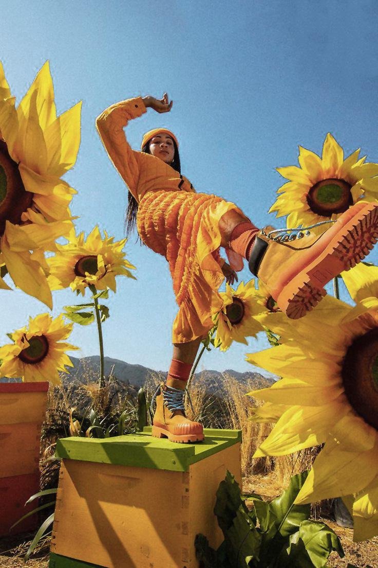 A young woman dancing in a field of sunflowers
